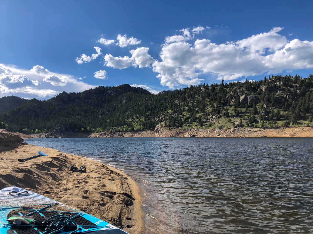 A paddle board is beached on the sandy shores of Gross Reservoir