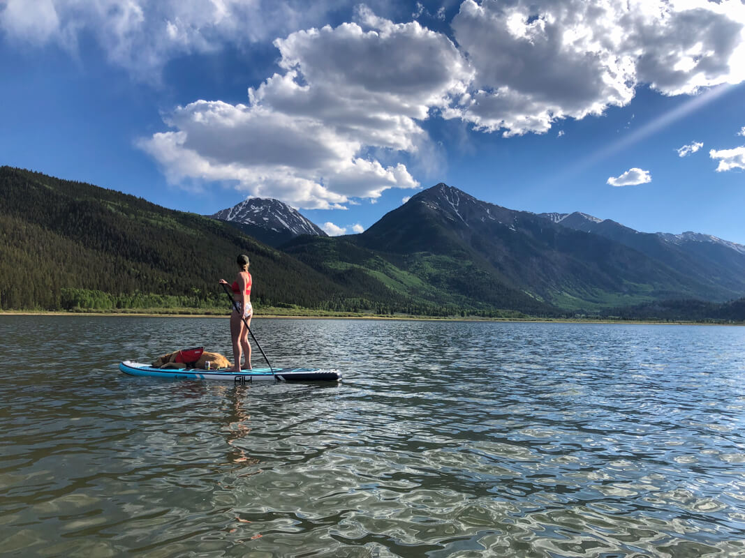 A paddle boarder gliding across upper Twin Lake in the early summer sun.