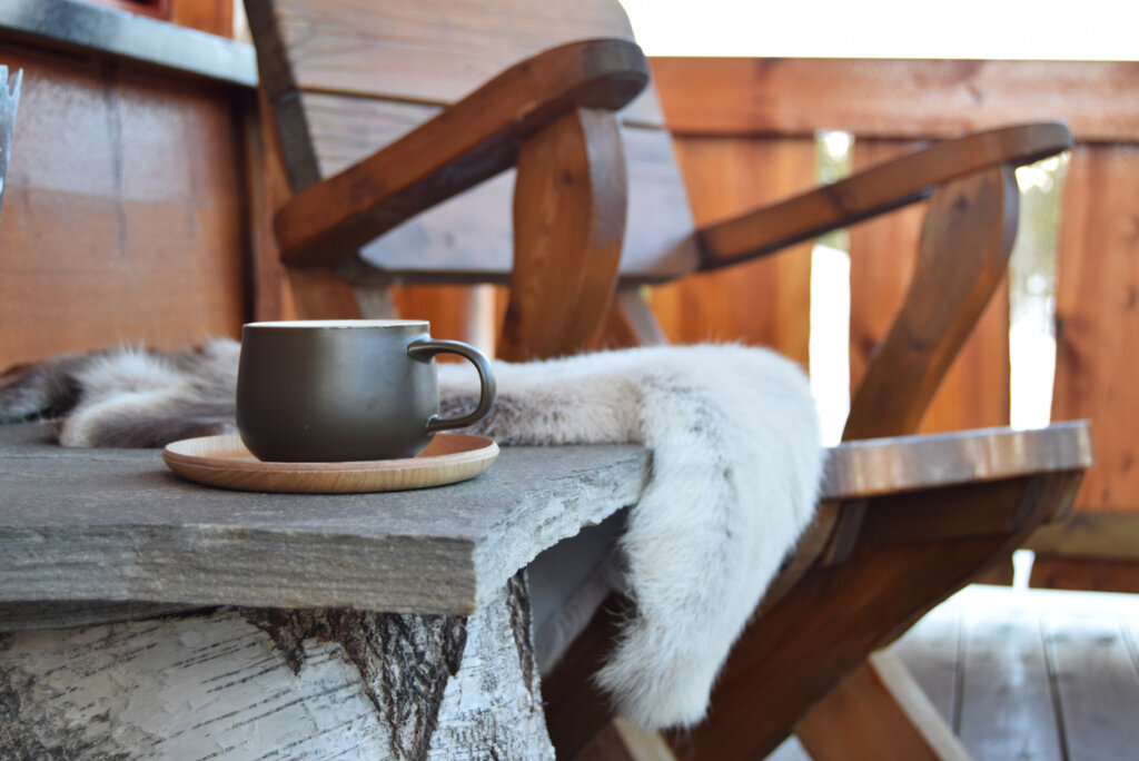 A large coffee mug resting on a table of an alpine lodge. 