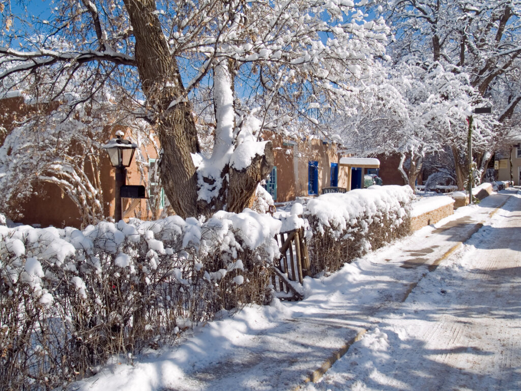 Snow covers the adobe houses and trees on Bent Street in Taos, NM. 